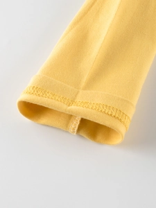 Detailed view of yellow long sleeve cotton t-shirt cuffs with precision stitching