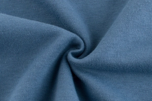 Vue macro de la texture épaisse du tissu tricoté bleu ciel pour sweat-shirt enfant
