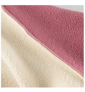 Detailed close-up of double-sided fleece fabric with high-density stitched edges and soft texture
