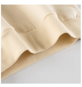 Detailed close-up of ribbed cuffs on a cream-colored cotton sweatshirt for children