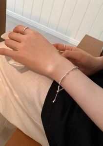 Dettaglio del bracciale con perline argentate e chiusura a scorrimento sul polso