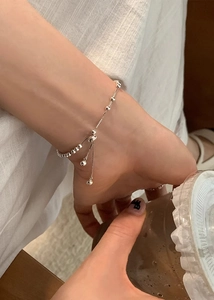 Bracciale a sfere argentate con chiusura regolabile indossato al polso per un look moderno