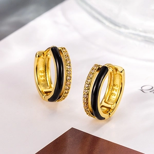Dettaglio macro di orecchini a cerchio S925 oro con smalto nero e zirconi lucidi