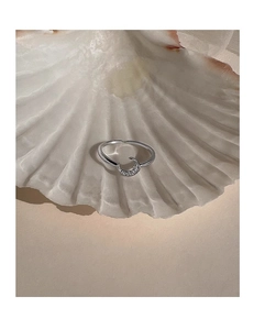 Close-up of sparkling moon crescent adjustable ring displayed inside a white shell
