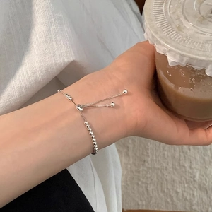 Bracciale a sfere in argento regolabile con chiusura a coulisse su una tazza di caffè