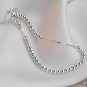 Bracciale regolabile in argento sterling con perle lucide su sfondo di seta bianca