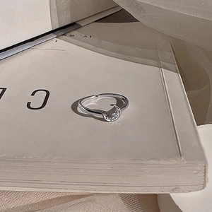 Elegant adjustable moon ring with sparkling cubic zirconia on a minimalist book