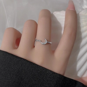 Minimalist silver moon ring with sparkling zircon stones worn on finger closeup