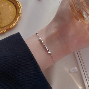 Bracelet cœur en argent élégant avec perles rondes porté par un mannequin chic