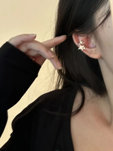 Close-up of star shaped ear cuff with layered double stars design in polished silver finish