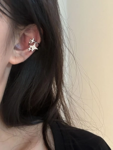 Detail of silver star ear cuff with rhinestones on a woman's ear without piercing