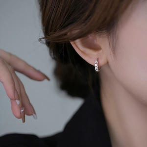 Close-up of S925 silver hoop earrings with V-shaped pavé zirconias worn by a model
