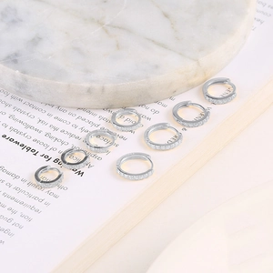 Detailed view of silver hoop earrings set with zircons and S925 hallmark stamp