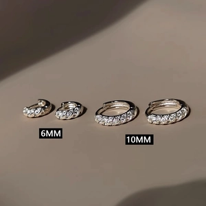 Detail view of 6mm and 10mm silver huggie earrings with cubic zirconia micro-pave setting