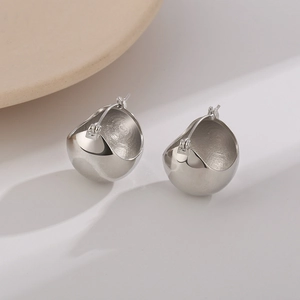 Macro shot of silver metallic spherical earrings with polished finish and snap closure