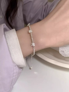 Macro detail of silver-plated bracelet with butterfly charm and irregular beads