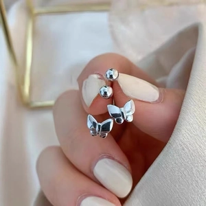 Handheld view of silver butterfly screw back earrings with high-polished metal finish