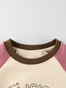 Fleece-lined kids sweatshirt with pink raglan sleeves and warm cream-colored body