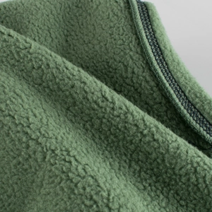 Close-up of deep green fleece fabric with high-quality stitching and soft texture
