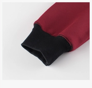 Detail of red fleece sweatshirt showing black ribbed cuffs and premium stitching finish