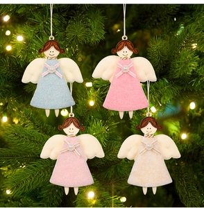 Détail de quatre ornements d'anges en bois colorés suspendus sur un sapin de Noël illuminé