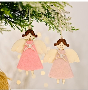 Détail d'anges de Noël artisanaux en bois et feutrine sur un sapin de Noël enneigé