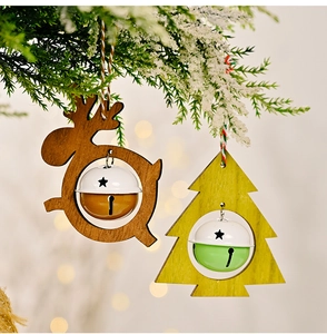 Close-up of wooden reindeer and Christmas tree ornaments with bells on pine branches