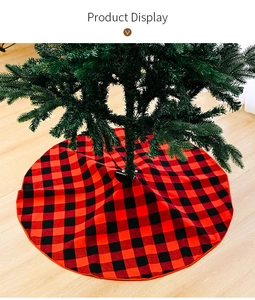 Close-up of red and black buffalo plaid Christmas tree skirt on light wooden floor