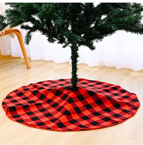 Detail of red and black buffalo plaid Christmas tree skirt on light wood floor