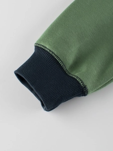 Close-up of grass green fleece sweatshirt with contrasting dark ribbed cuffs