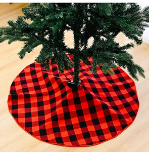 Close-up of red and black buffalo plaid Christmas tree skirt on light wooden floor