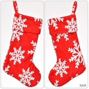 Front and back detail of a plush red Christmas stocking with white 3D snowflake patterns
