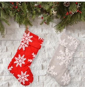 Close-up of red and grey plush Christmas stockings with white snowflake patterns