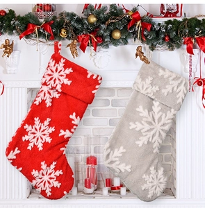 Detail of red and grey Christmas stockings with plush snowflake patterns on a mantel