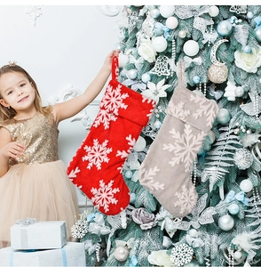 Detail of red and grey plush Christmas stockings with 3D snowflake patterns