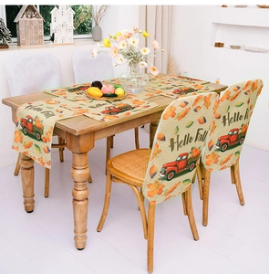Detail of harvest table runner and chair covers with pumpkin truck and maple leaves