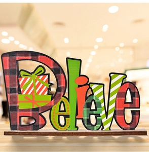 Macro view of Christmas 'Believe' wooden ornament featuring festive buffalo plaid patterns