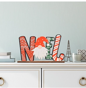 Detailed close-up of NOEL wooden Christmas ornament with gnome design on a white surface