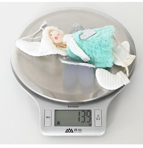 Plush heart angel ornament weighing 13.9g on a digital scale for Christmas decor