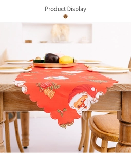 Close-up of red Christmas table runner with Santa print and scalloped edges on wood table