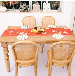 Detail of red Christmas table runner with Santa print and laser-cut scalloped edges