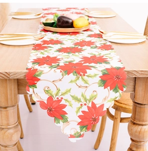 Close-up of festive Christmas table runner with poinsettia patterns and scalloped edges