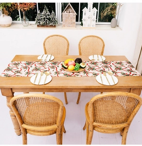 Detailed view of Christmas table runner with holly berry print and scalloped lace edges