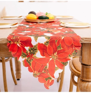 Close-up of Christmas table runner with poinsettia print and laser-cut hollow edges