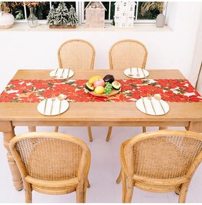 Detail of Christmas table runner with red poinsettia floral patterns and scalloped edges