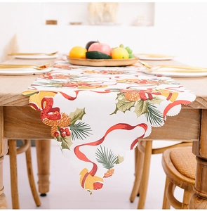 Detail of Christmas table runner with festive bells and laser-cut wavy edges on wood table