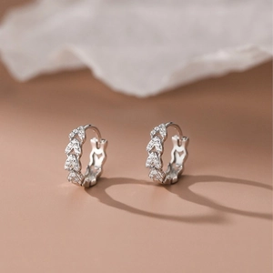 Silver hoop earrings with heart-shaped patterns and sparkling pavé zircon stones