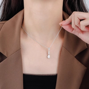 Elegante silberne Tropfenanhänger-Halskette getragen von einem Model im modernen Büro-Stil