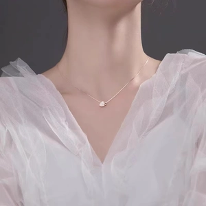 Elegant rose gold heart pendant necklace with shimmering crystals on female model