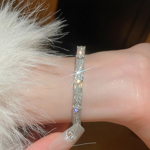Macro shot of silver-tone clover bangle with shimmering zircons and floral cutouts